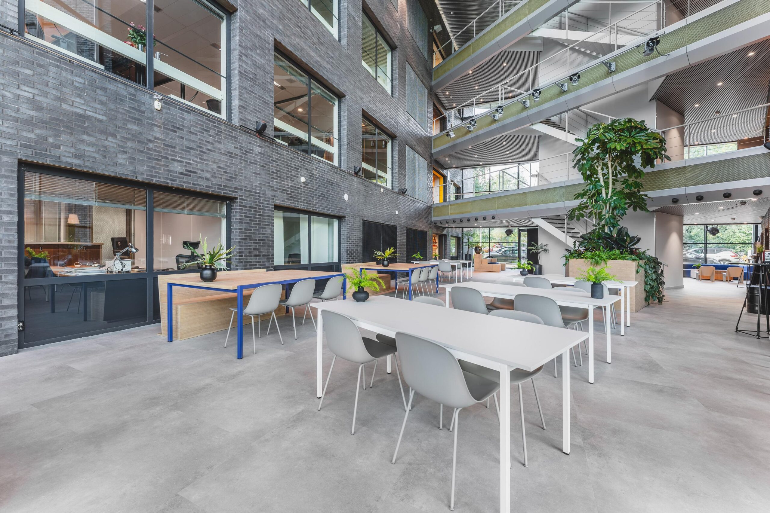 Moderne, open kantoorlobby aan de Prof. W.H. Keesomlaan met zitplaatsen, grote ramen en veel lichtinval.